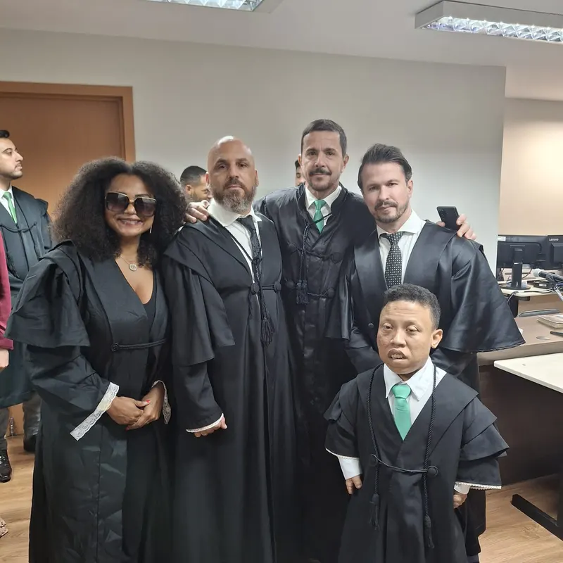 Advogada Criminalista Bruna Vitebro de toga ao lado de colegas advogados